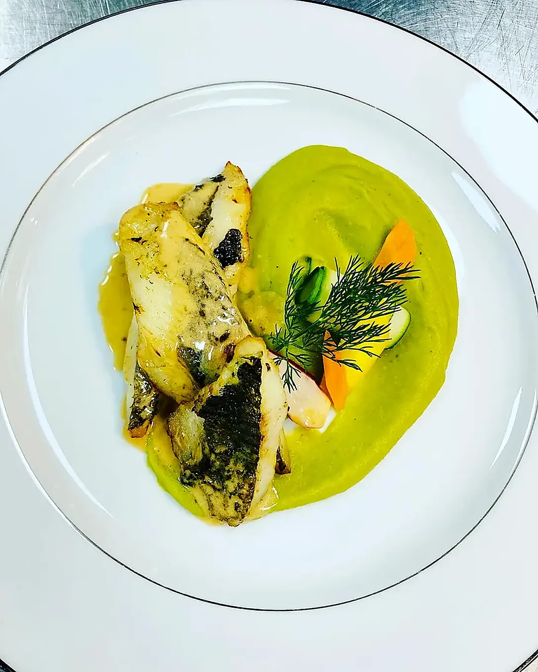 Dressage d'un filet de poisson sur velouté de petits pois par le chef