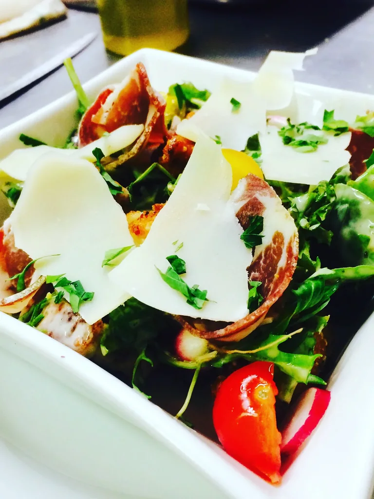 Salade de roquette, jambon cru, tomates et copeaux de parmesan