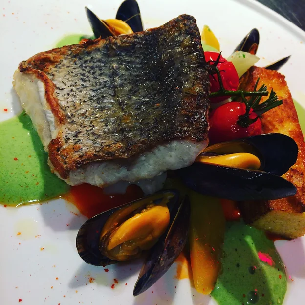 Filet de bar rôti, moules et purée d'herbes
