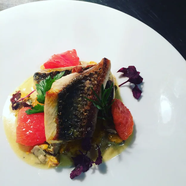 Filet de poisson grillé, agrumes et jeunes pousses