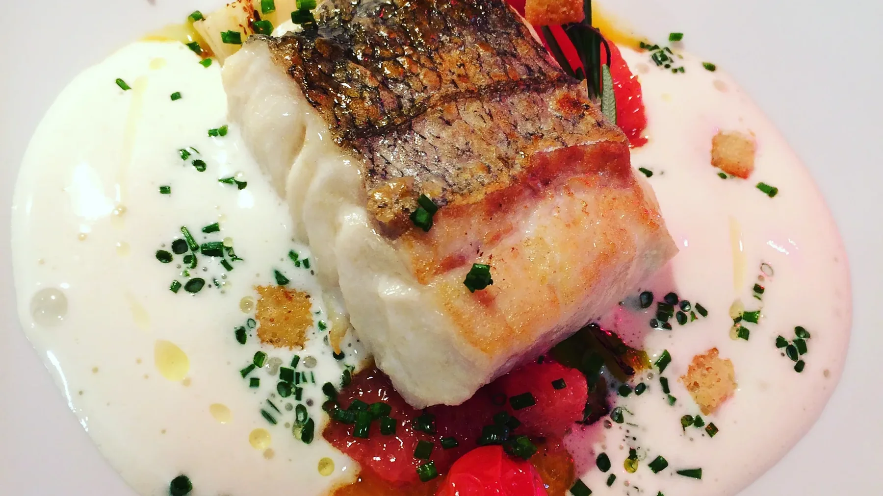 Filet de poisson rôti sur crème à la ciboulette et tomates cerises, dressé par le chef traiteur Christian Mve Soh à Bordeaux