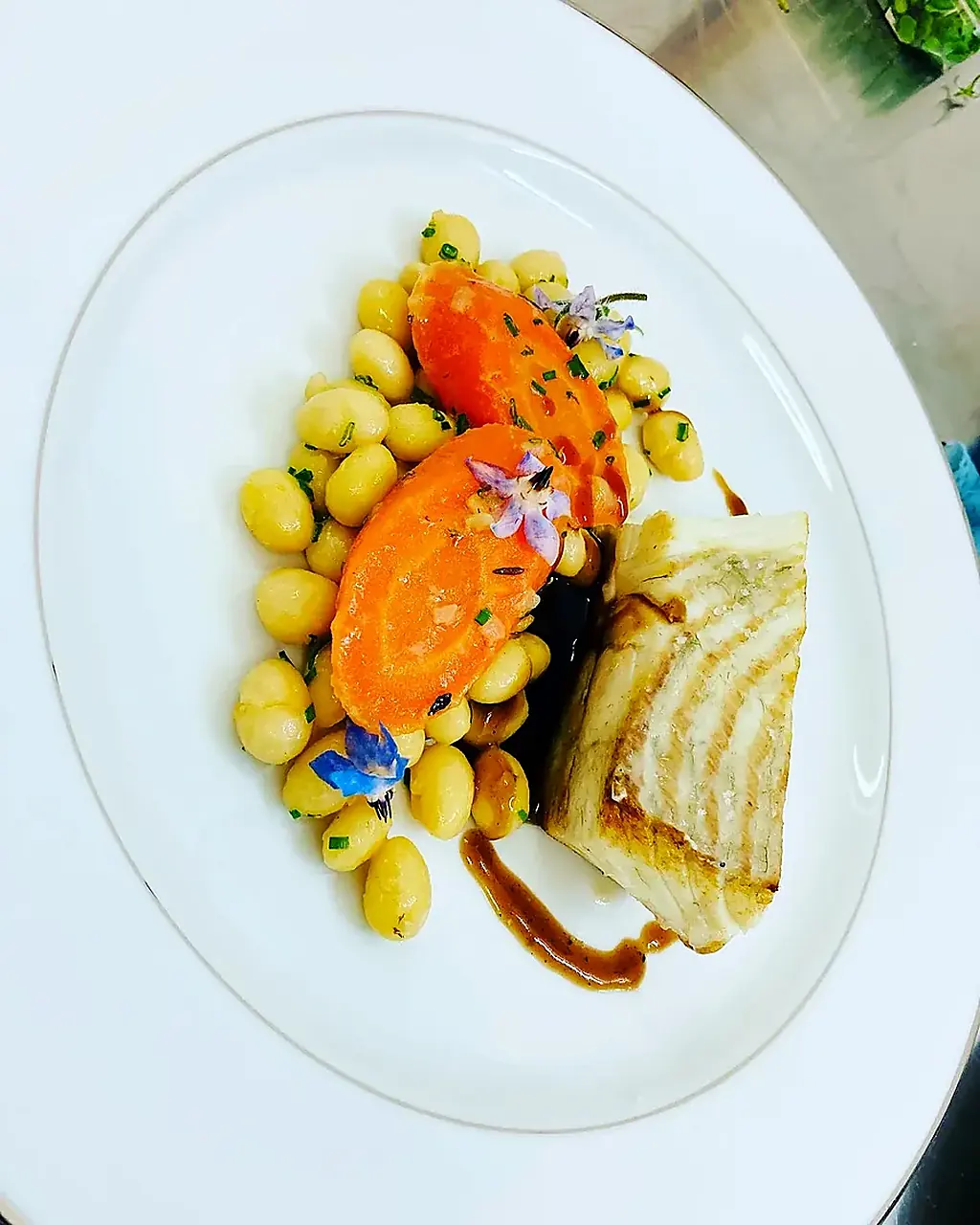 Saumon, gnocchis et carotte fleurie dressés à l'assiette par le traiteur à Bordeaux