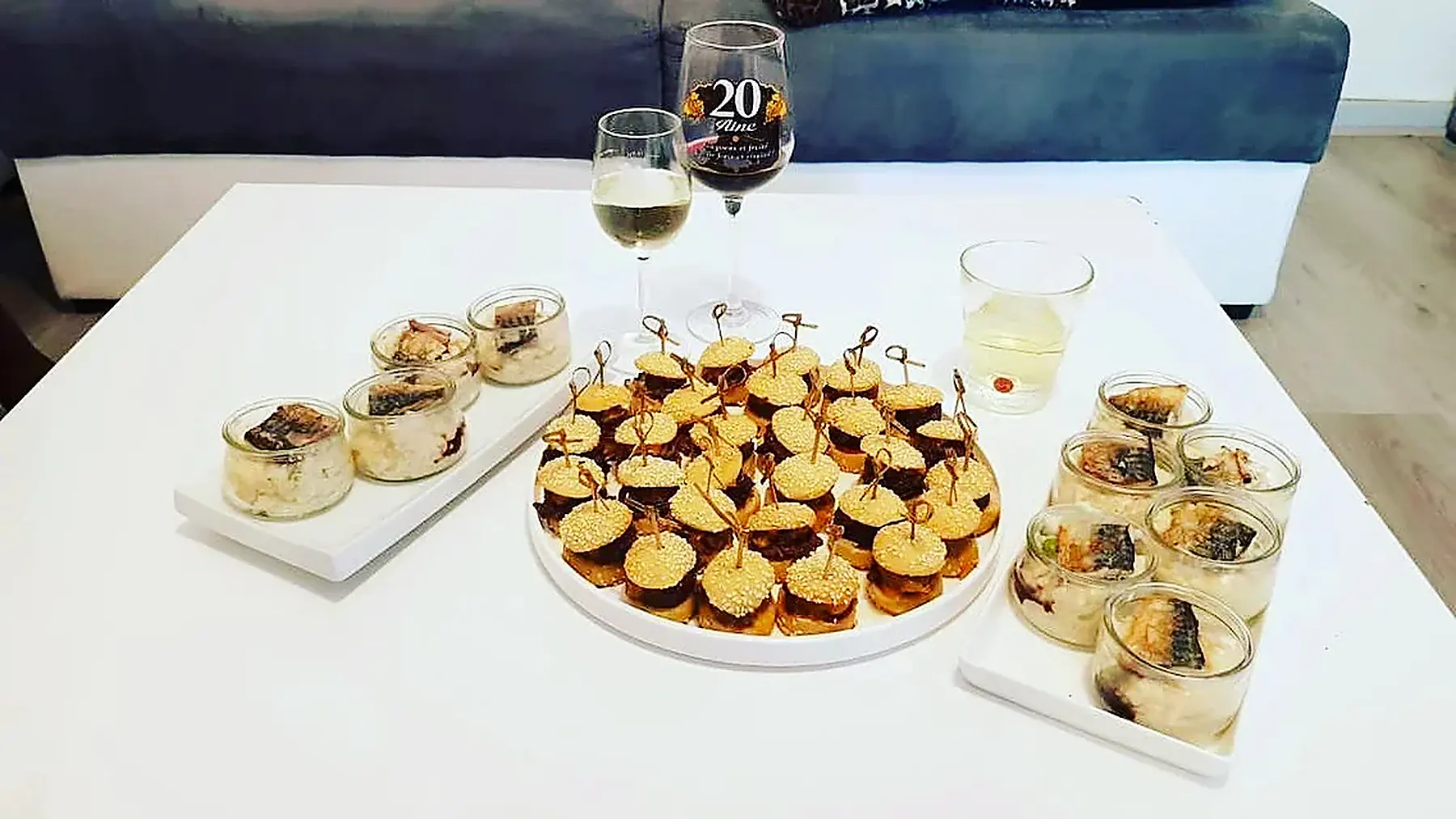 Buffet de réception dressé sur nappe blanche avec verrines et bouchées